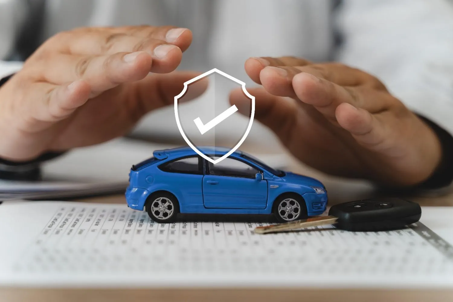Hands held over a car beside a policy document
